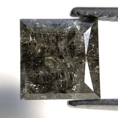 a diamond is being held up by a pair of tongs