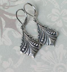 "These beautiful Art Deco silver plated brass earrings are reminiscent of Downton Abbey and designs from the 1920s and 1930s. They hang from stainless steel leverback earwires and hang 1 3/4\" long. Comes in a lovely gift box with ribbon." Handmade Silver Jewelry For Vintage Events, Silver Sterling Silver Art Deco Earrings, Vintage Sterling Silver Jewelry For Vintage Events, Sterling Silver Vintage Jewelry For Vintage Events, Sterling Silver Vintage Jewelry For Events, Antique Silver Vintage Dangle Jewelry, Vintage Antique Silver Dangle Jewelry, Antique Silver Vintage Drop Earrings, Vintage Antique Silver Dangle Earrings