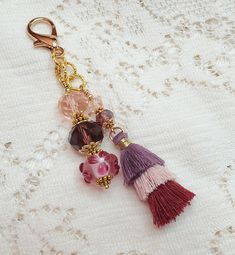 a keychain with charms on it sitting on top of a lace doily