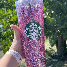 a hand holding up a pink starbucks cup with lots of glitter on the outside and inside