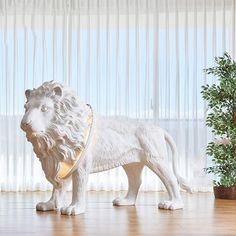 a white lion figurine standing in front of a window