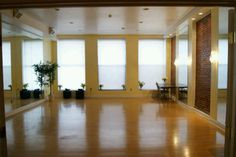 an empty room with wooden floors and large windows