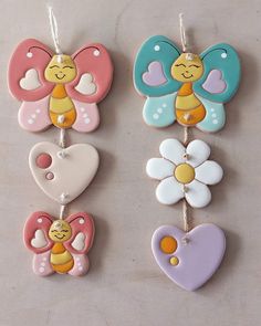 three different shaped cookies hanging from strings with hearts and flowers in the shape of butterflies