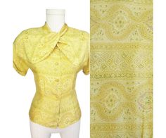 RARE and Unique 1940s blouse that you'll instantly Love! Never before have we seen a bow that buttons. So OOAK! [F E A T U R E S] * smooth light silk * wonderful front "bow" ~ two wide cross-over ties that attach to lower of two buttons at each shoulder * charming paisley print * beautiful palette in soft shades of marigold, yellow, peridot green and caramel * princess silhouette  * drop shoulders and short cuffed sleeves * closes via same-fabric covered buttons, all in wonderful condition * Label: "Tailored by Adelaar" and "Pure Silk" This blouse looks beautiful with a pencil or flared skirt and over-the-top femme with 40s wide leg pants! [M E A S U R E M E N T S] Best fits M. Please go by measurements below. Bust   38" Waist   33" Hem   36.50" Shoulders   15-16" no shoulder seam Sleeve l 1940s Blouse, Selling On Instagram, Light Silk, Green Paisley, Yellow Silk, Fabric Covered Button, Silk Material, Blouse Vintage, Blouse Top