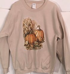 Autumn Pumpkin & Corn Husks T Shirt, (Sweatshirt,  Hoodie Available On Request) #794a For Sweatshirts and Hoodies please contact me to request a custom order. Youth Sizes available Design will be printed on the front of the garment unless requested otherwise. The exception to this is hoodies where zippers and pockets may obstruct the printing space. 5XL NOT available in LONG SLEEVE LAVENDER & GREEN  (Please order short sleeve style or a different color)   6XL available in short sleeve only and  is NOT available in LAVENDER or GREEN Long sleeve colors may vary from pictured depending on availability from the garment mills.   COLOR: Fabric colors can affect the final print colors. This image shows the design on white. Computer monitors can depict colors slightly differently as well.  Design Cotton Hooded T-shirt For Fall, Fall Hooded Graphic Print T-shirt, Hooded Graphic Print T-shirt For Fall, Casual Fleece T-shirt For Fall, Fall Crew Hoodie With Screen Print, Fall Hooded T-shirt With Letter Print, Fall Crew Neck Hoodie With Screen Print, Fall Letter Print Hooded T-shirt, Crew Neck Screen Print Hoodie For Fall