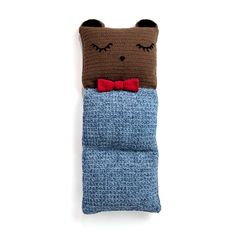 a crocheted cat pillow with a red bow tie