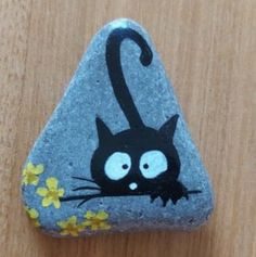 a rock with a black cat painted on it