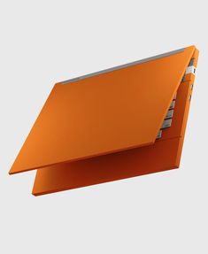 an orange folder is hanging upside down on a gray background with the top section partially open