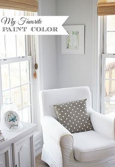 a white chair sitting in front of two windows