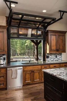 an open kitchen with wooden cabinets and stainless steel dishwasher in the center, along with marble counter tops