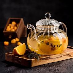 a glass tea pot filled with lemon and herbs