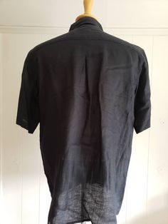 This is a vintage, Bruno, black, short sleeved, washable linen shirt with a collar and buttons down the front. The measurements are: Armpits: 24.5 inches across Length from back of the neck: just shy of 30 inches Don't forget to stop in at my other Etsy shop... http://www.etsy.com/shop/xtdesigns If you have a wish list or are looking for something specific, please ask. I may have exactly what you are looking for. As always please convo me with any questions or concerns regarding this item or wit Fitted Short Sleeve Black Shirt With Buttons, Black Linen Button Shirt, Black Collared Short Sleeve Shirt With Button Closure, Black Collared Linen Shirt, Black Linen Collared Shirt, Classic Black Linen Shirt, Black Johnny Collar Short Sleeve Shirt, Black Short Sleeve Shirt With Spread Collar, Black Cotton Short Sleeve Shirt With Spread Collar