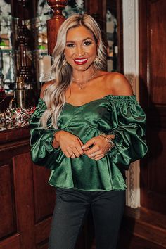 This 'Genuine Reaction Babydoll Top' in hunter green is stunning! Features a lightweight satin material, a wide smocked neckline, long loose sleeves with ruffled elasticized seams, and feminine stitching in the front. The half back smocked design gives it a flattering silhouette that falls into a waist-length hemline.                                   Measurements S :  Bust 28", Hip 32", Length 19", Sleeve Length 21", Waist 26".  M :  Bust 30", Hip 34", Length 20", Sleeve Length 22", Waist 28". Loose Sleeves, Babydoll Top, Satin Material, Model Fits, Waist Length, Hunter Green, Hip Length, Off Shoulder Blouse, One Shoulder Blouse