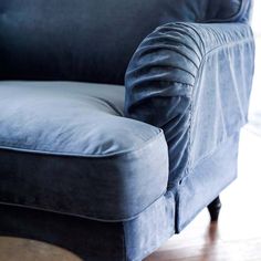 a blue couch sitting on top of a hard wood floor