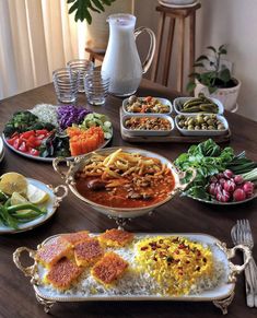 a table topped with lots of different types of food on plates and serving trays