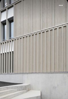 a man riding a skateboard down the side of a cement staircase next to a building