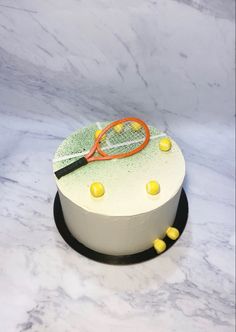 a tennis racket on top of a cake with yellow candies around the edges