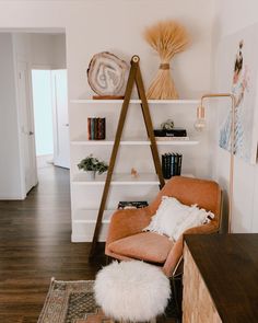 a living room with a chair, bookshelf and rug