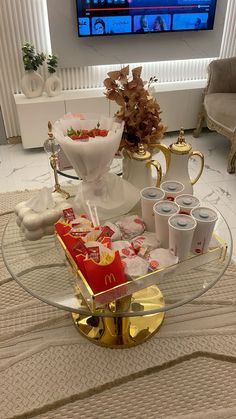 a glass table topped with drinks and snacks