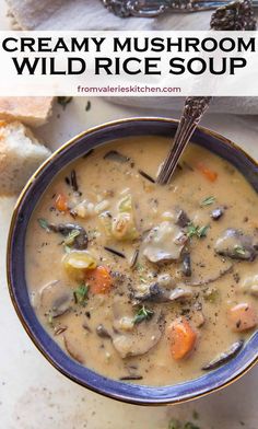 creamy mushroom wild rice soup in a blue bowl with spoons and bread on the side