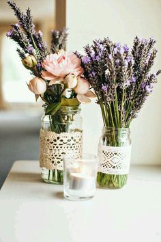 two vases filled with flowers sitting on top of a table