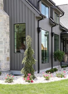 a house with grey siding and green grass