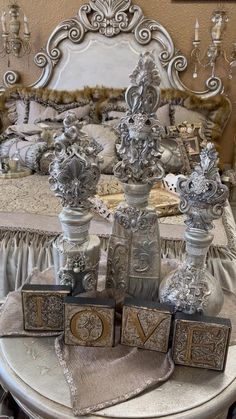 an ornate bed with silver decorations on top of it and two wooden blocks that spell out the word love