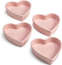 three pink heart shaped dishes sitting next to each other