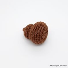 a crocheted heart shaped object sitting on top of a white surface with the word, my amigurum farm written below it