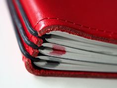 an open red leather book with white pages