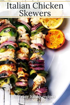 an image of chicken skewers on a plate with oranges and other food