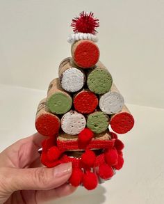 a hand holding a christmas tree made out of wine corks