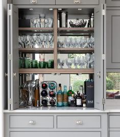 an open cabinet filled with glasses and bottles