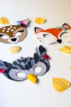 three masks with leaves on them and one has a fox mask in the middle for decoration