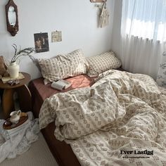 an unmade bed with pillows and blankets on it in a bedroom next to a window