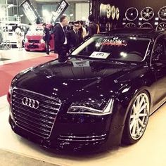 an audi car is on display in a showroom with people looking at the cars