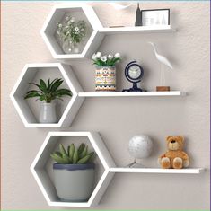 three white hexagonal shelves with plants and stuffed animals