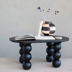 a table with a vase on it and a book sitting on top of the table