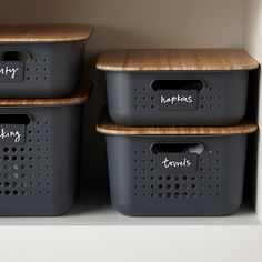 three storage bins with labels on them in a closet