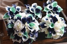 wedding bouquets with blue and white flowers are sitting on a mirror