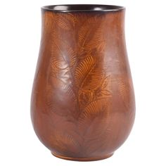 a brown vase with leaves on it