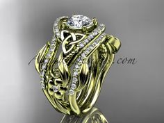 a yellow gold wedding ring set with an intricate floral design and diamond accents on the band