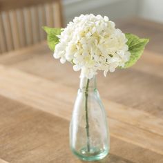 there is a small vase with flowers in it sitting on the table, ready to be used as a centerpiece