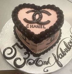 a heart shaped cake with chanel logo on the top and name written in cursive writing