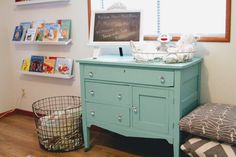 a blue dresser in a child's room with bookshelves