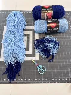 yarn and scissors are laid out on a cutting board