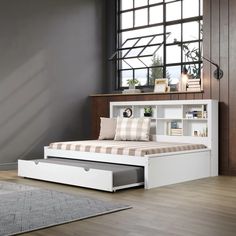 a white daybed with storage underneath it in a living room next to a large window