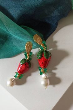 Sicilian earrings made of: - Sicily ceramic Strawberries (30 mm x 20 mm); - Baroque Pearls (12 mm - 14 mm), white color; - Faceted Agate stones (6 mm), green color; - Brass earrings. Lenght : 7,5 cm / 2,76 inches * SHIPPING * Your order will be shipped within 1-3 business days from your purchase. You can choose between 2 shipping methods: STANDARD MAIL (NOT TRACEABLE) It is a cheap and fast shipping method, but NOT TRACEABLE. Chapeau Atelier is not responsible for any postal disruptions, delays Summer White Jewelry With Fruit Design, Resin Jewelry For Summer Gifts, Summer Gift Jewelry Made Of Resin, White Resin Earrings For Summer, Summer Fruit Design White Jewelry, Elegant Dangle Jewelry With Fruit Design, Elegant Fruit Design Dangle Jewelry, Multicolor Fruit Design Earrings For Gift, Handmade White Enamel Earrings