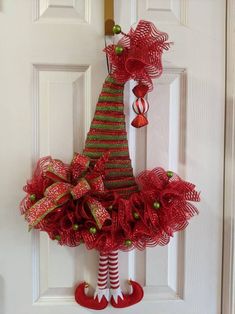 a christmas tree door hanger with red and green decorations on it's side