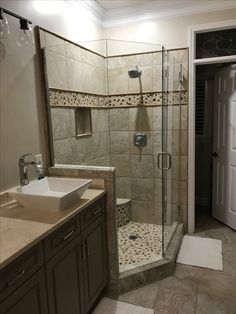 a bathroom with a walk in shower next to a sink